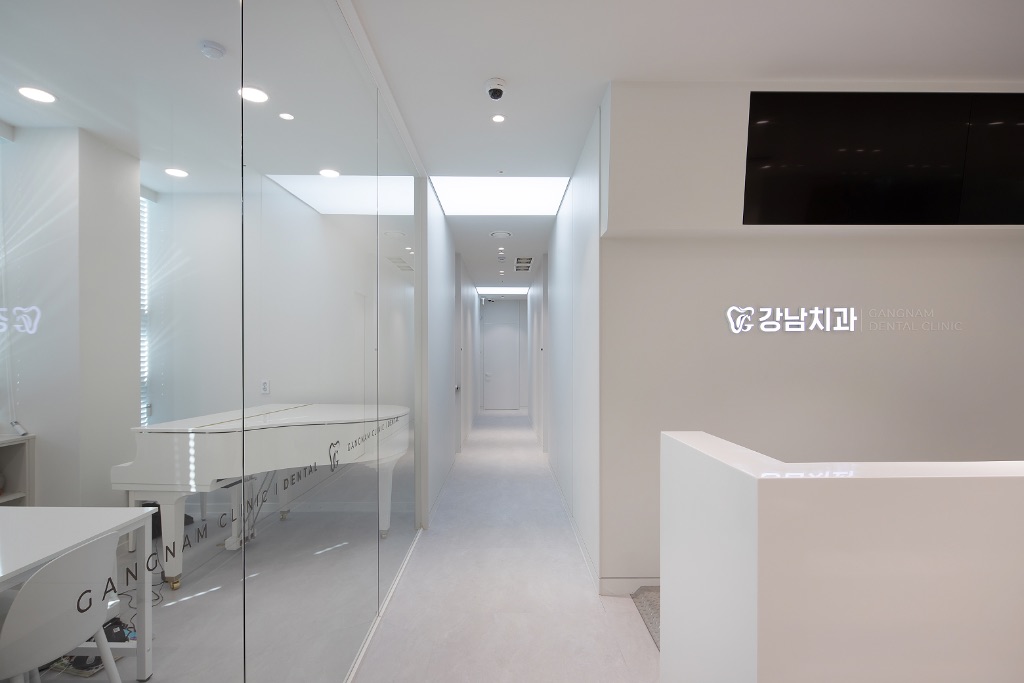 강남치과의원 접수대와 복도 - 강남치과 로고